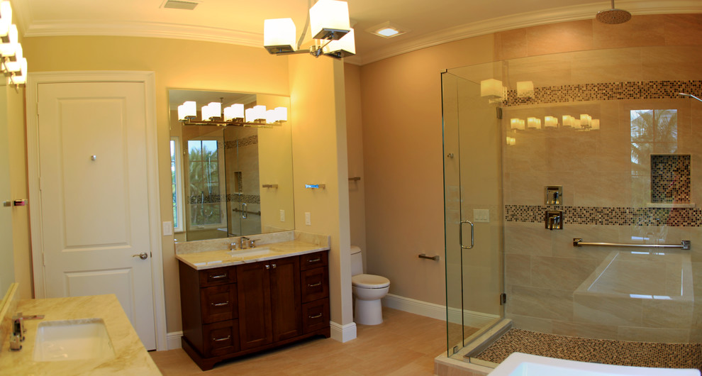Photo of a large beach style master bathroom in Miami with recessed-panel cabinets, medium wood cabinets, a freestanding tub, a corner shower, a one-piece toilet, yellow tile, porcelain tile, beige walls, porcelain floors, an undermount sink, quartzite benchtops, beige floor and a hinged shower door.
