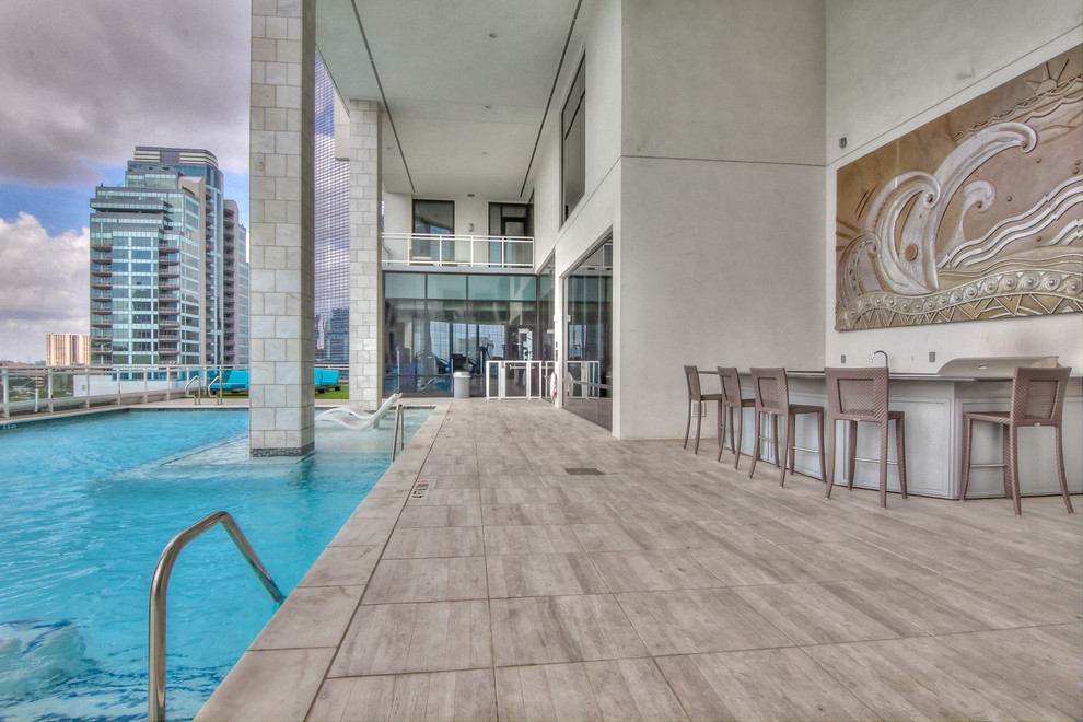 Photo of an expansive contemporary rooftop rectangular natural pool in Houston with decking.