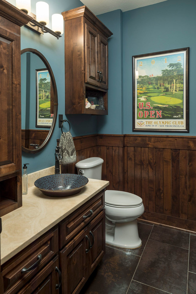 Design ideas for a country powder room in Minneapolis with raised-panel cabinets, dark wood cabinets, blue walls, a vessel sink and grey floor.