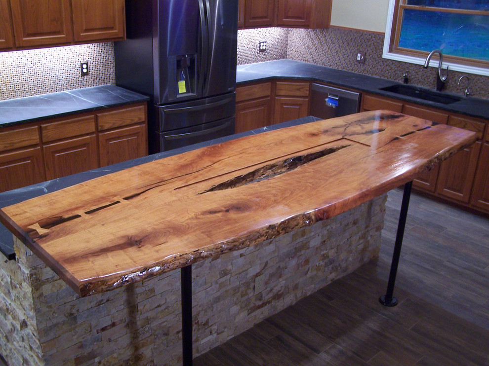 Inspiration for a rustic ceramic tile kitchen remodel in Austin with medium tone wood cabinets, wood countertops, an island, a double-bowl sink, multicolored backsplash, mosaic tile backsplash and black appliances
