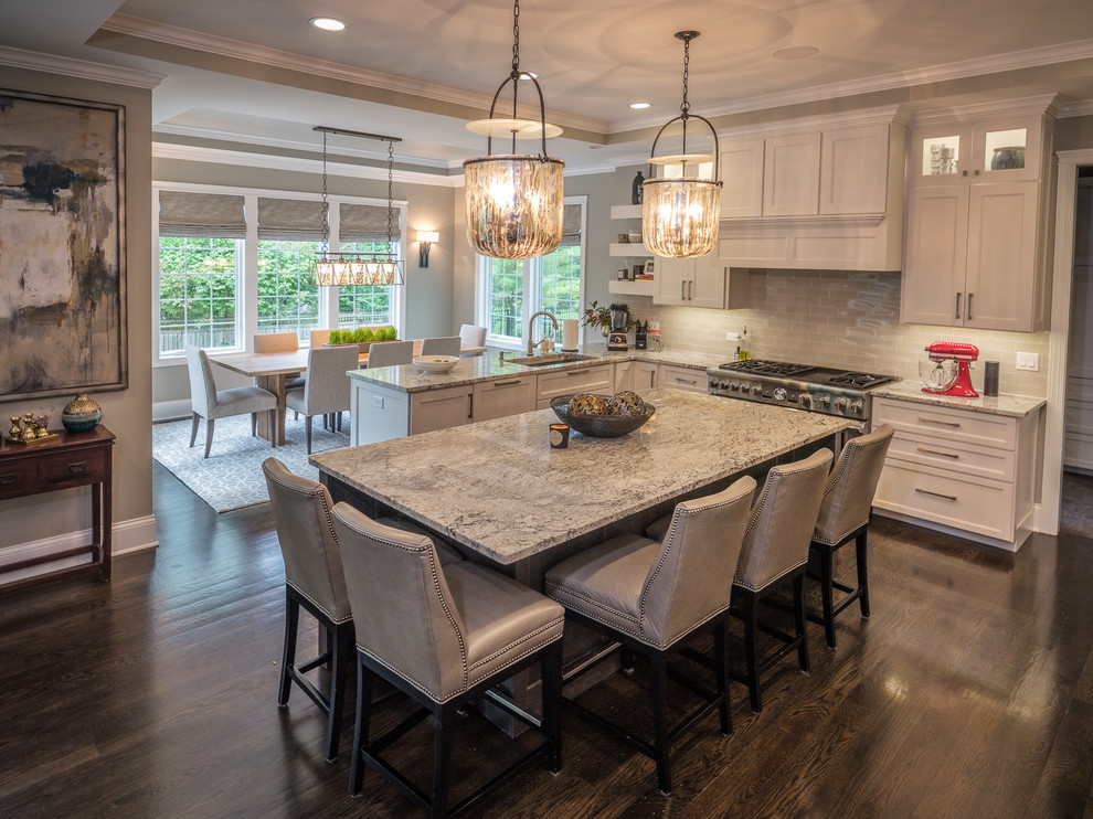Mid-sized transitional u-shaped eat-in kitchen in Chicago with an undermount sink, recessed-panel cabinets, white cabinets, granite benchtops, white splashback, subway tile splashback, stainless steel appliances, dark hardwood floors, with island and brown floor.