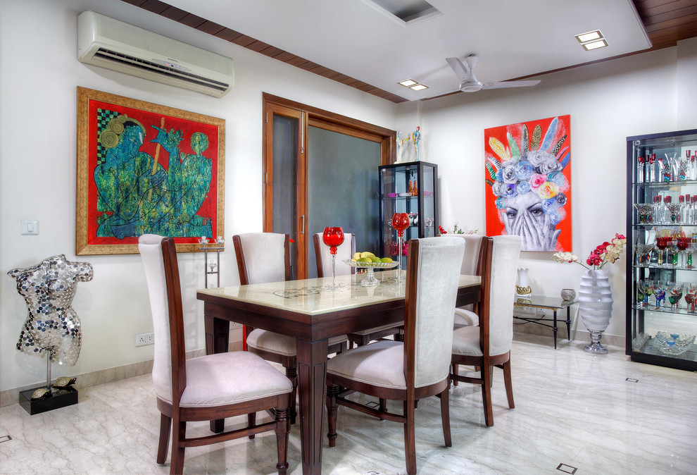 Photo of a mid-sized eclectic dining room in Delhi with white walls, marble floors and white floor.