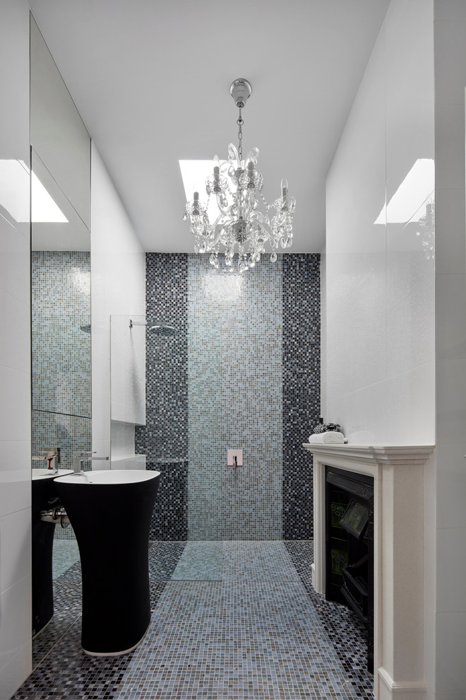 This is an example of a mid-sized contemporary bathroom in Melbourne with recessed-panel cabinets, a curbless shower, blue tile, mosaic tile, white walls, mosaic tile floors, a pedestal sink and solid surface benchtops.