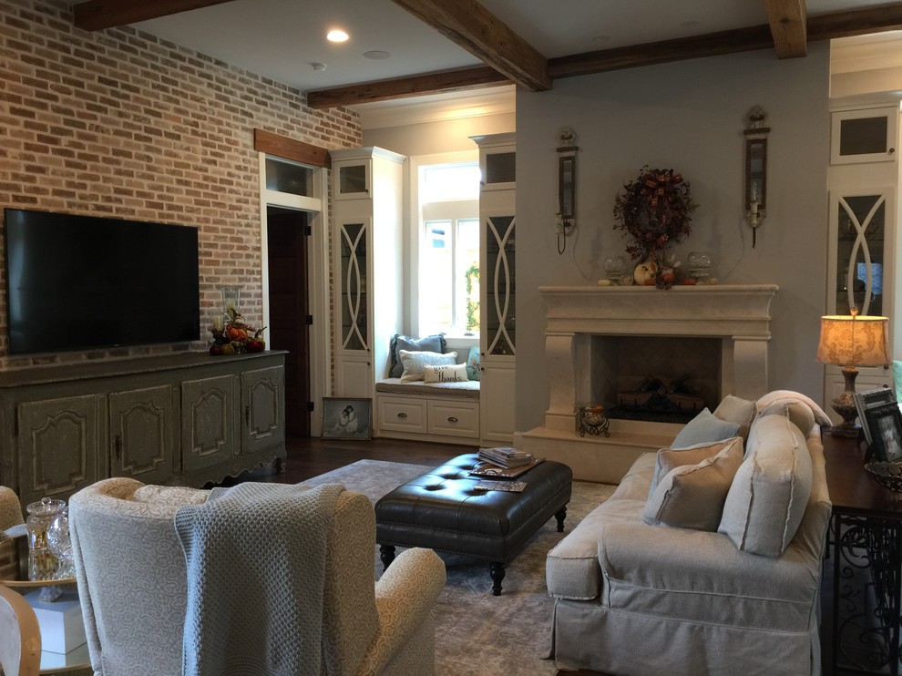 Inspiration for a large traditional open concept living room in Houston with grey walls, dark hardwood floors, a standard fireplace, a plaster fireplace surround and a wall-mounted tv.