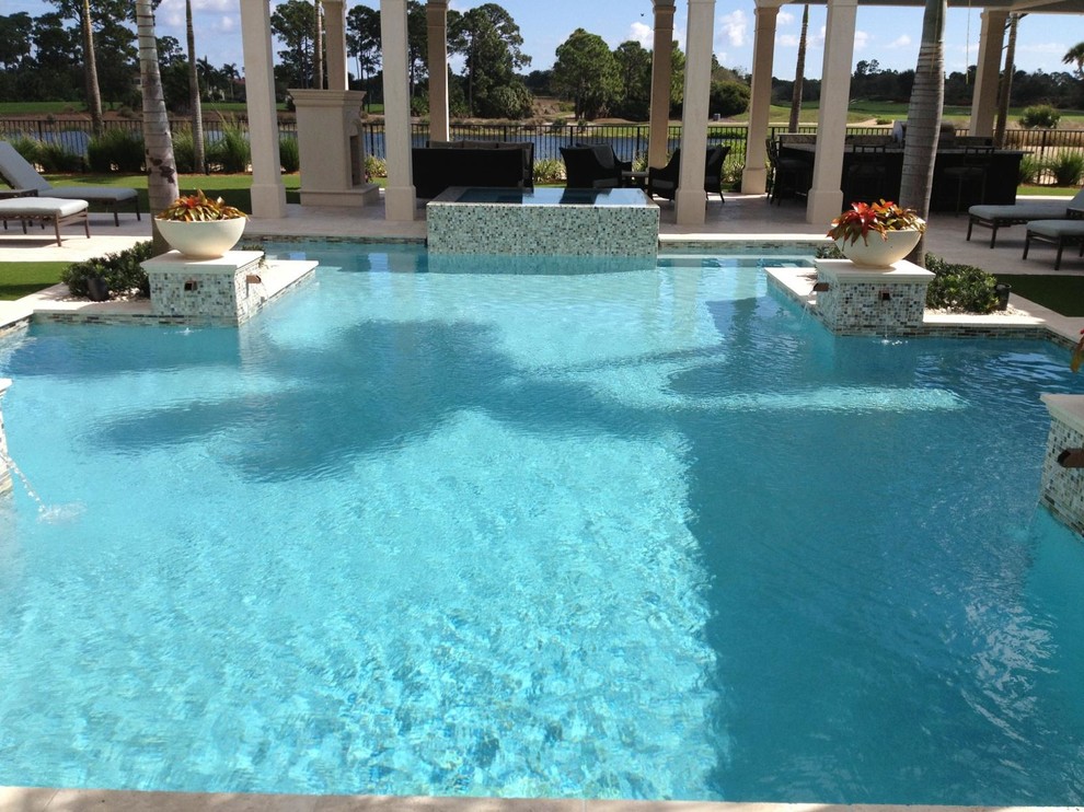 Hot tub - large tropical backyard custom-shaped natural hot tub idea in Miami
