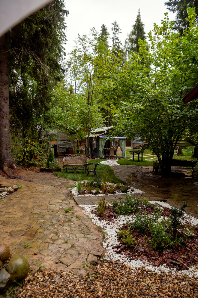 На фото: беседка во дворе частного дома среднего размера на заднем дворе в современном стиле с летней кухней и покрытием из гравия с
