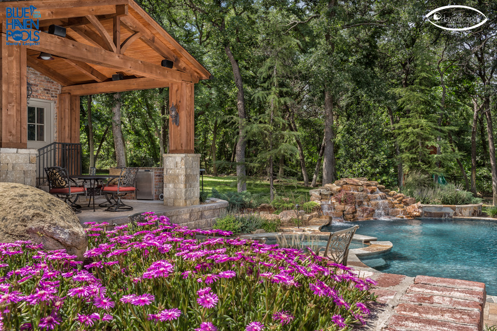 Photo of a large country backyard custom-shaped natural pool in Oklahoma City with concrete pavers.