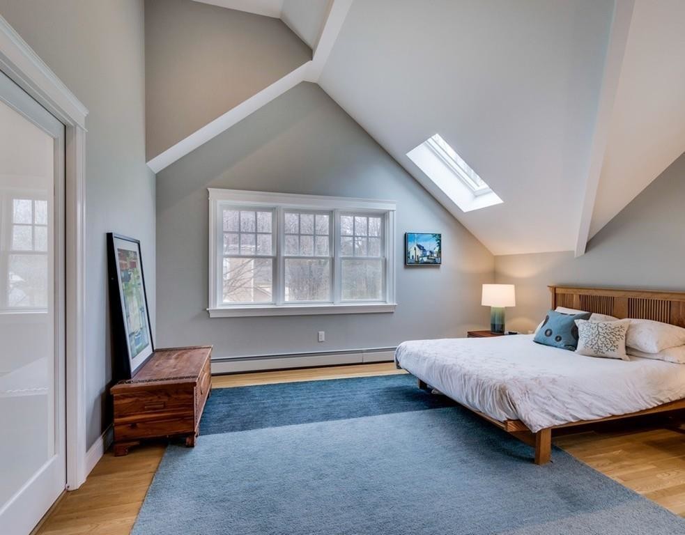 Photo of a mid-sized scandinavian master bedroom in Boston with grey walls and light hardwood floors.