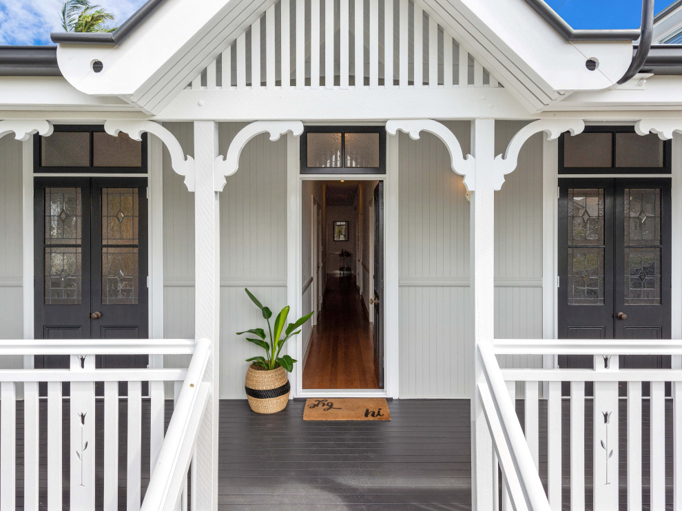 Design ideas for a mid-sized beach style two-storey grey house exterior in Brisbane with wood siding, a hip roof, a metal roof and a white roof.