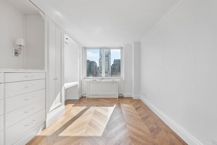 Example of a mid-sized transitional guest light wood floor and beige floor bedroom design in New York with white walls and no fireplace