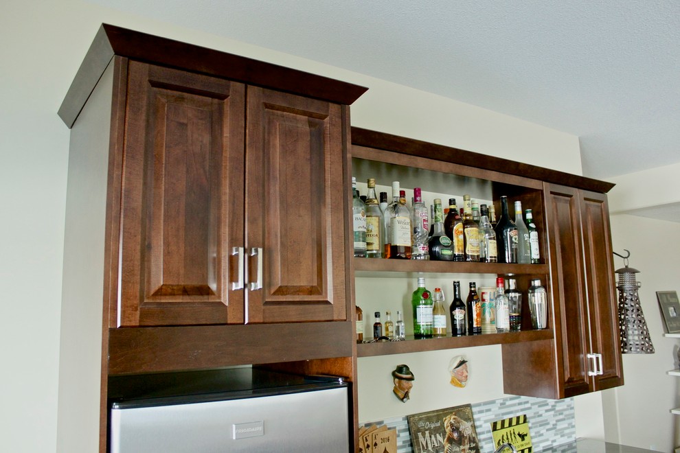 Photo of a small arts and crafts single-wall wet bar in Vancouver with a drop-in sink, raised-panel cabinets, dark wood cabinets, tile benchtops, grey splashback, glass tile splashback and ceramic floors.