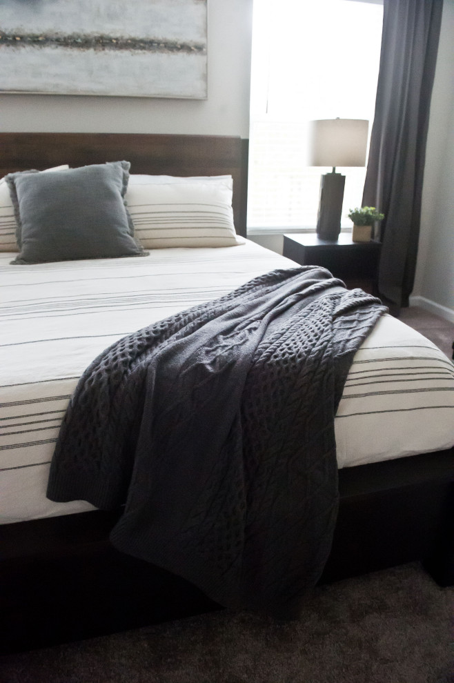 Modern master bedroom in Charlotte with grey walls and carpet.