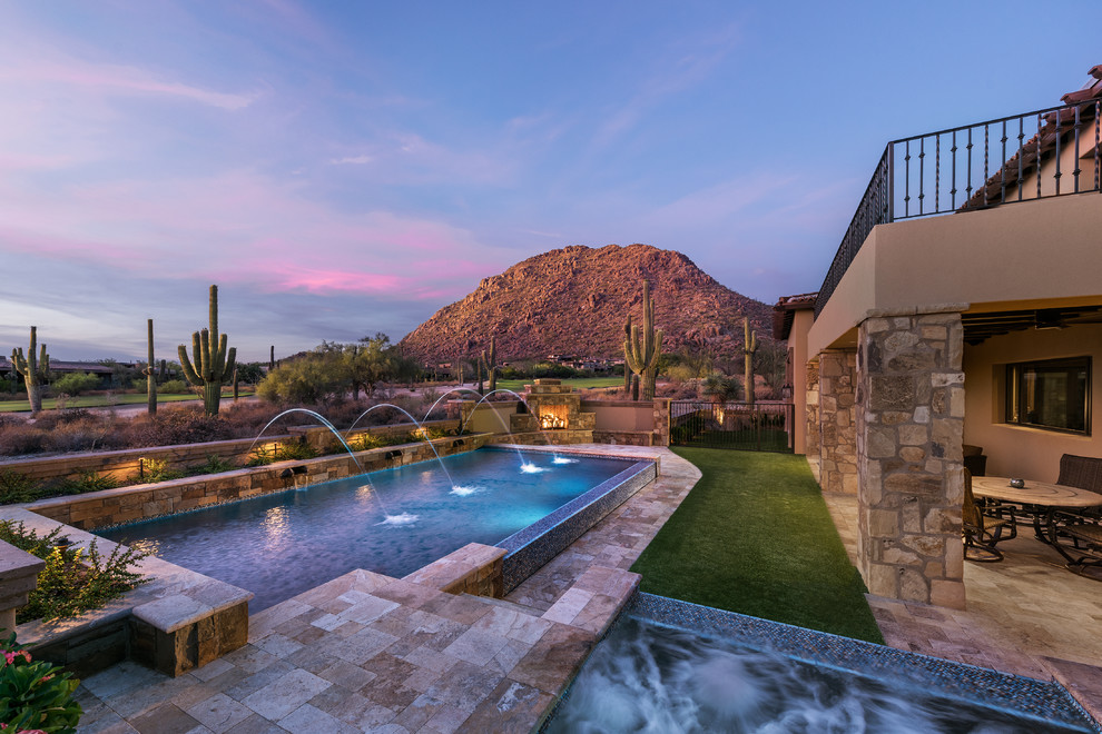 Inspiration for a large country backyard rectangular infinity pool in Phoenix with a hot tub and natural stone pavers.