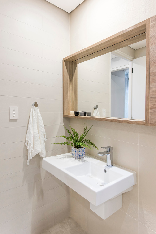 This is an example of a large midcentury powder room in Perth with furniture-like cabinets, medium wood cabinets, beige tile, ceramic tile and marble benchtops.