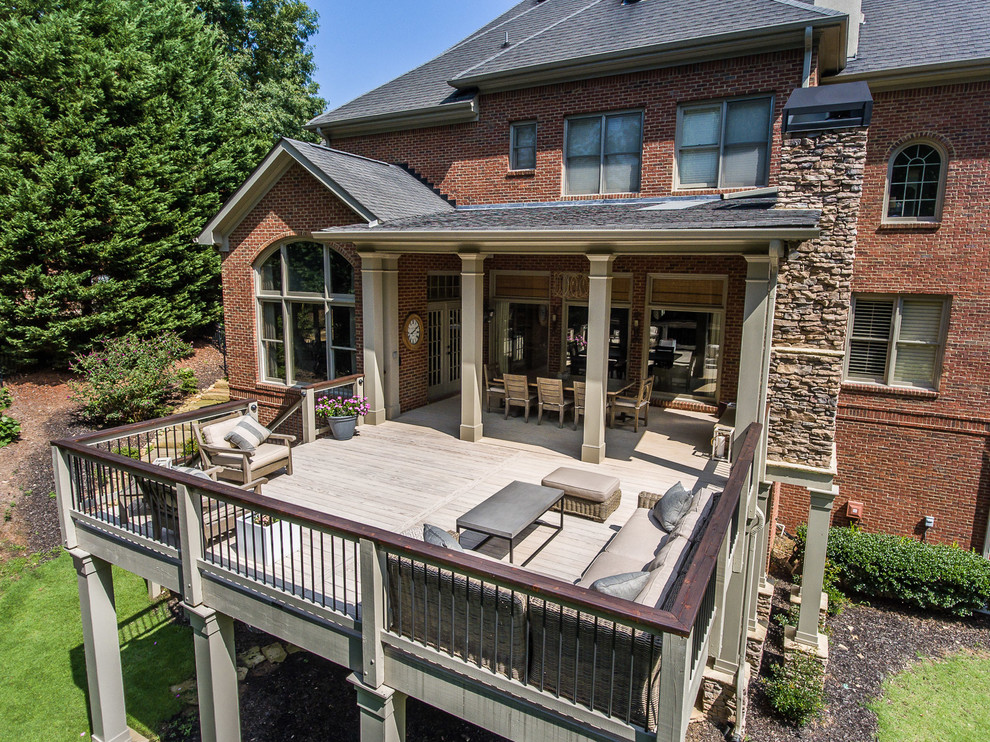 Inspiration for a large transitional backyard deck remodel in Atlanta with a roof extension