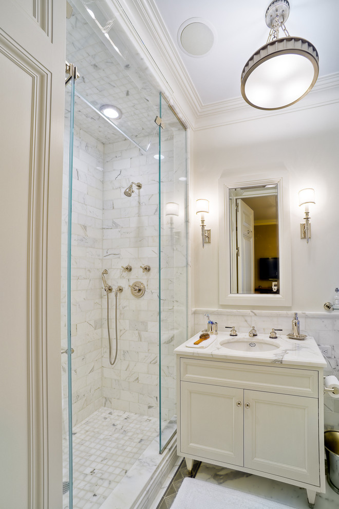 Design ideas for a large traditional master bathroom in New York with an undermount sink, white cabinets, marble benchtops, an alcove shower, white tile, gray tile, multi-coloured tile, white walls, marble floors, recessed-panel cabinets and a drop-in tub.