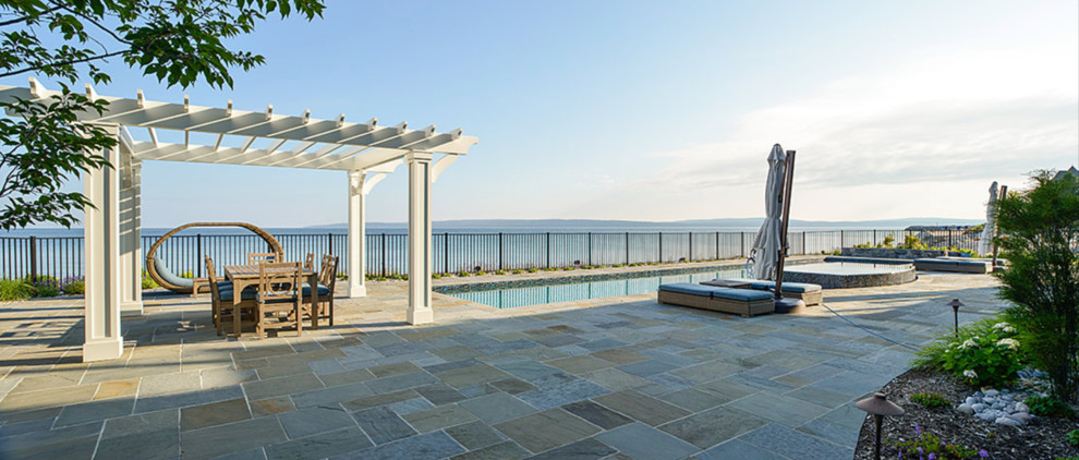 Example of a large transitional backyard stone and custom-shaped natural hot tub design
