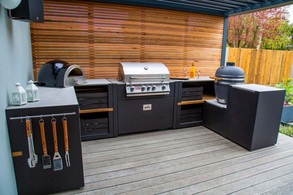 Réalisation d'une terrasse en bois arrière design de taille moyenne avec une cuisine d'été et une pergola.