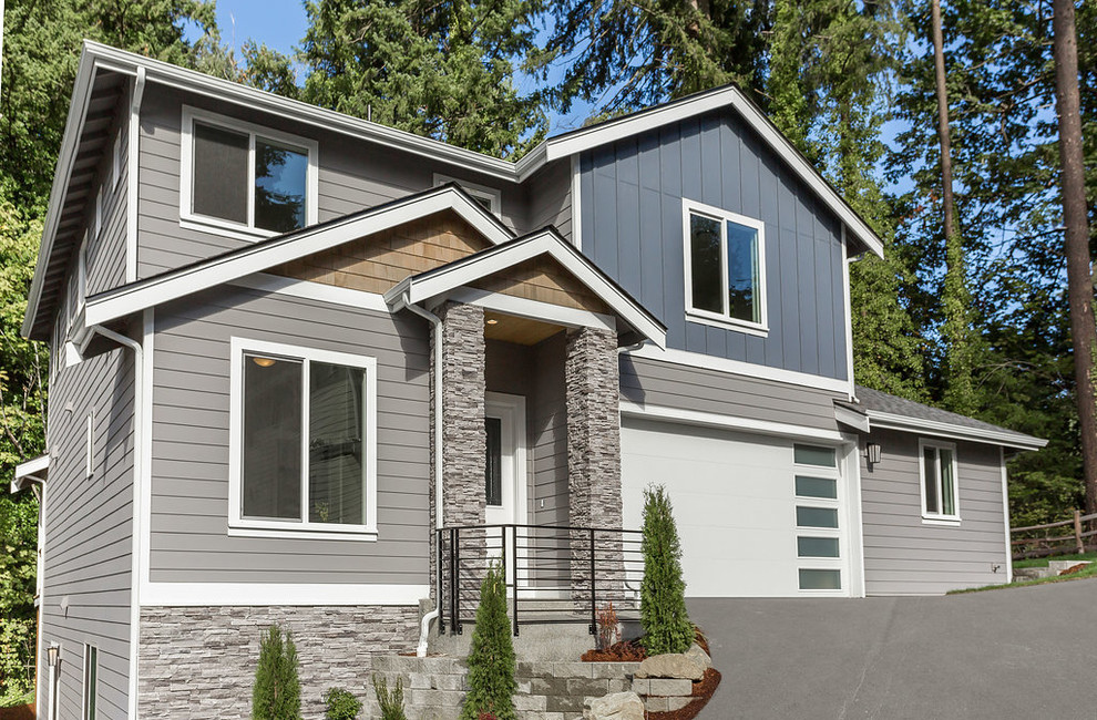 Inspiration for a large traditional three-storey grey house exterior in Seattle with wood siding, a shingle roof and a gable roof.