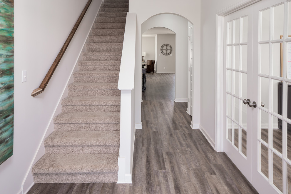 Example of a small transitional medium tone wood floor entry hall design with white walls