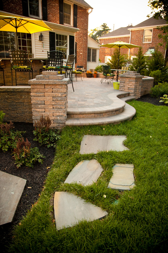 Photo of a mid-sized traditional backyard patio in Philadelphia with an outdoor kitchen, natural stone pavers and no cover.