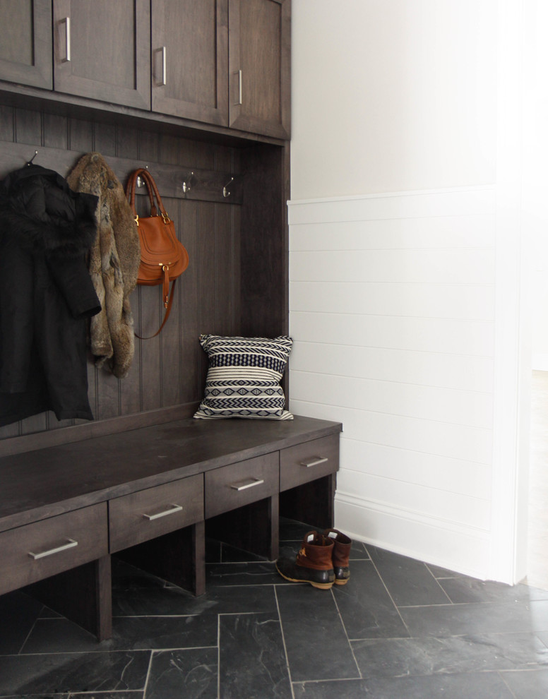 This is an example of a large transitional mudroom in Chicago with white walls, slate floors and black floor.