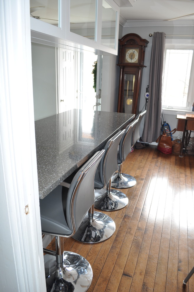 Small transitional u-shaped porcelain tile and gray floor eat-in kitchen photo in Toronto with an undermount sink, shaker cabinets, white cabinets, quartz countertops, white backsplash, porcelain backsplash, stainless steel appliances and an island