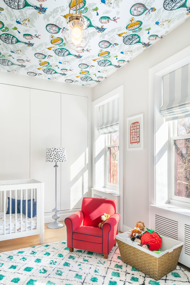 Inspiration for a transitional nursery in New York with grey walls, medium hardwood floors and brown floor.