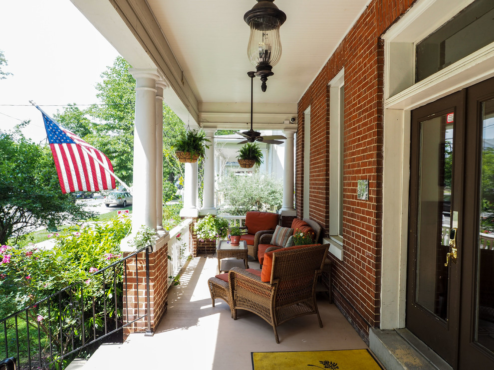 Mid-sized traditional front yard verandah in DC Metro with concrete slab and a roof extension.