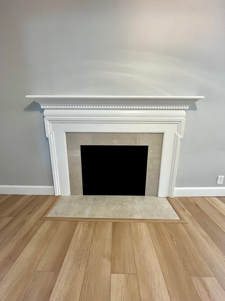 Example of a mid-sized transitional vinyl floor and brown floor kitchen/dining room combo design with white walls, a standard fireplace and a tile fireplace