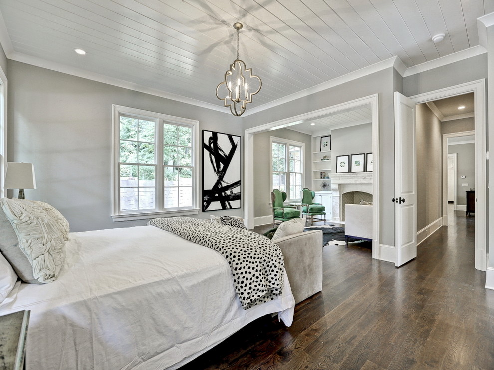 This is an example of a transitional master bedroom in Atlanta with grey walls and dark hardwood floors.