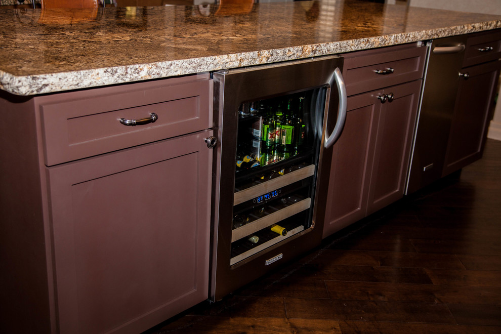 Example of a large transitional l-shaped dark wood floor eat-in kitchen design in Phoenix with an undermount sink, recessed-panel cabinets, white cabinets, granite countertops, multicolored backsplash, glass tile backsplash, stainless steel appliances and an island