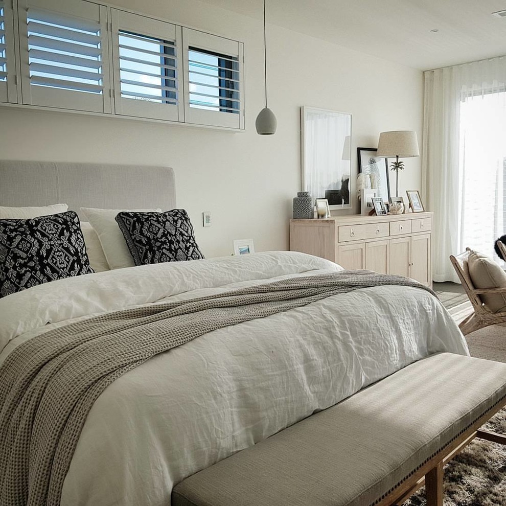 Inspiration for a mid-sized beach style master bedroom in Sunshine Coast with white walls, carpet and beige floor.