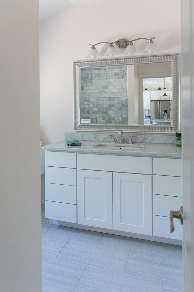 Inspiration for a traditional master bathroom in Boston with shaker cabinets, white cabinets, an alcove shower, a two-piece toilet, gray tile, marble, grey walls, ceramic floors, an undermount sink, marble benchtops, grey floor and a hinged shower door.