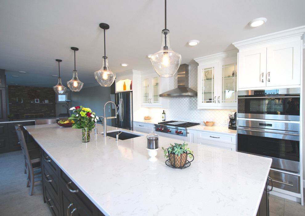 Transitional galley limestone floor eat-in kitchen photo with an undermount sink, white cabinets, quartz countertops, white backsplash, ceramic backsplash, stainless steel appliances and an island