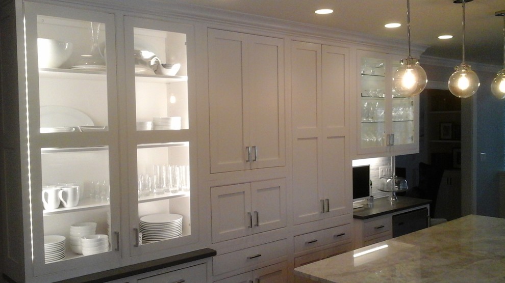 Mid-sized transitional l-shaped light wood floor eat-in kitchen photo in Newark with a double-bowl sink, shaker cabinets, white cabinets, solid surface countertops, multicolored backsplash, stone tile backsplash, stainless steel appliances and an island