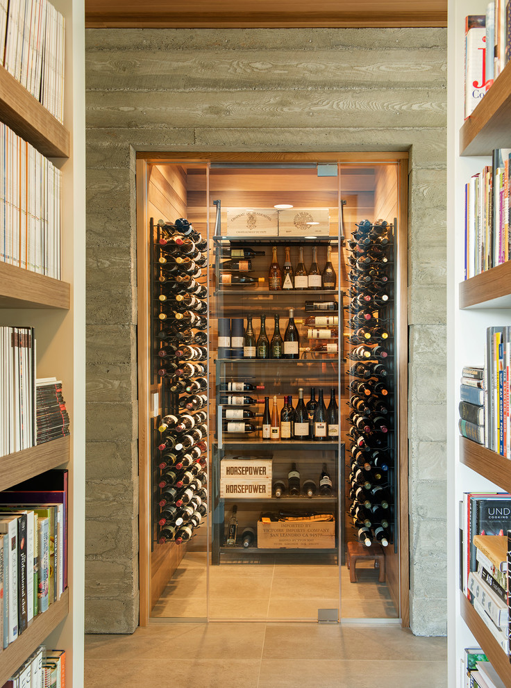 Mid-sized contemporary wine cellar in Other with storage racks and beige floor.