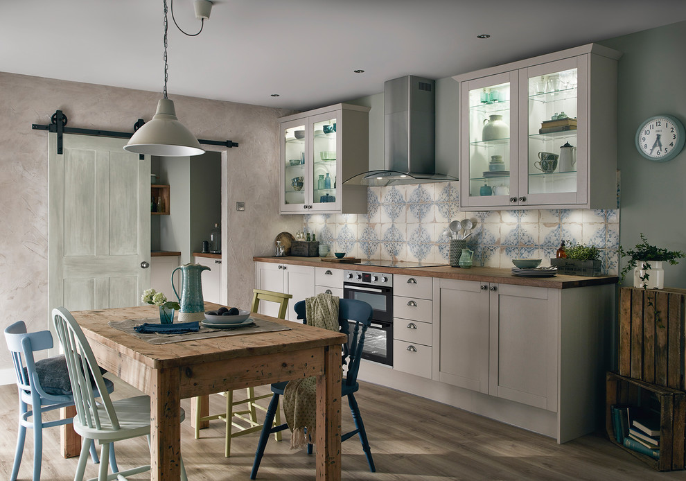 Mid-sized traditional single-wall kitchen in Other with shaker cabinets, wood benchtops, blue splashback, mosaic tile splashback, panelled appliances, no island and grey floor.