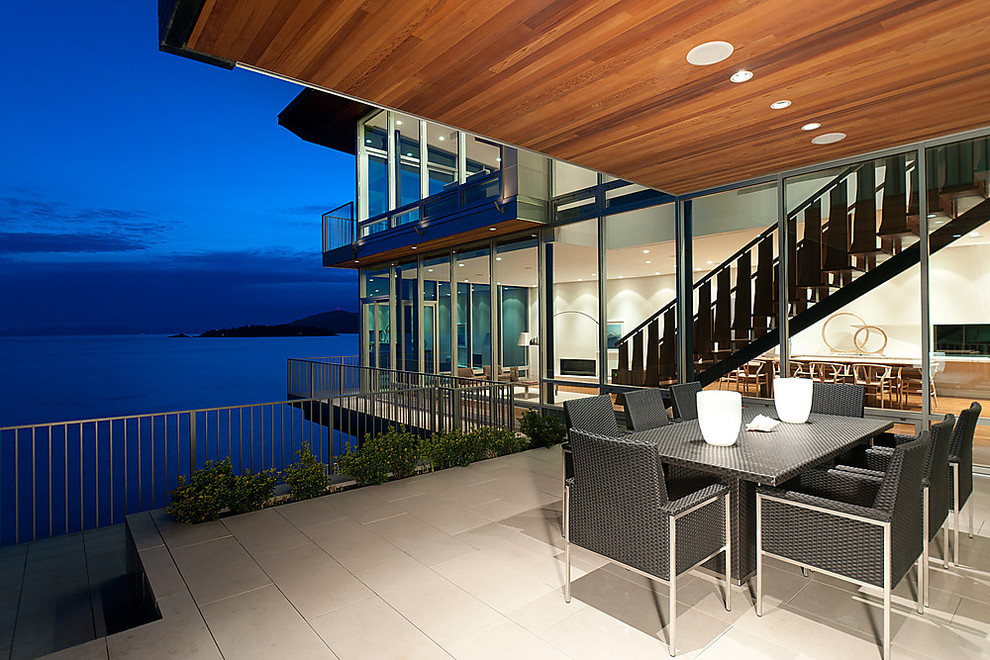 This is an example of a contemporary deck in Vancouver with a roof extension.