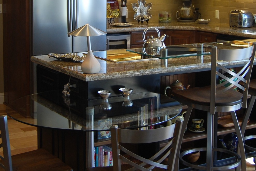 Example of a mid-sized transitional u-shaped medium tone wood floor open concept kitchen design with an undermount sink, raised-panel cabinets, medium tone wood cabinets, granite countertops, beige backsplash, stone tile backsplash, stainless steel appliances, beige walls and an island