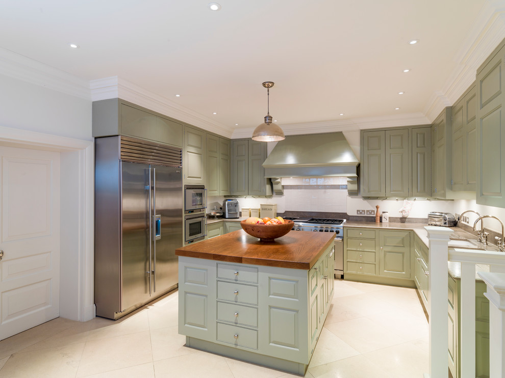 Photo of a large traditional galley open plan kitchen in Other with an undermount sink, raised-panel cabinets, green cabinets, limestone benchtops, limestone floors and with island.