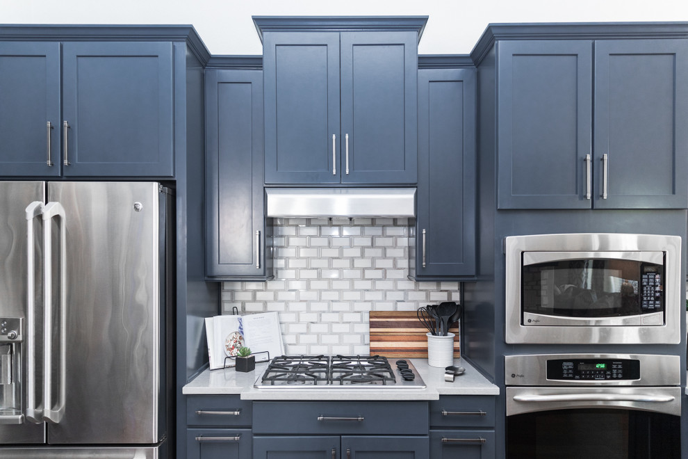 Example of a mountain style kitchen design in Austin with blue cabinets, mosaic tile backsplash, stainless steel appliances and no island
