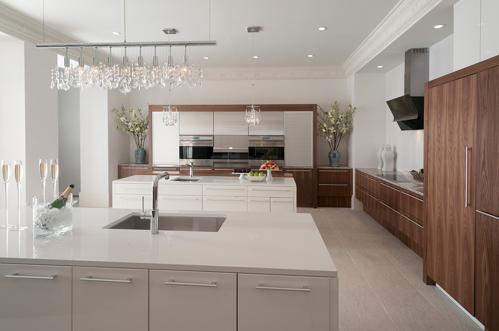 Large contemporary l-shaped eat-in kitchen in Houston with a single-bowl sink, flat-panel cabinets, white cabinets, glass benchtops, stainless steel appliances, multiple islands and ceramic floors.