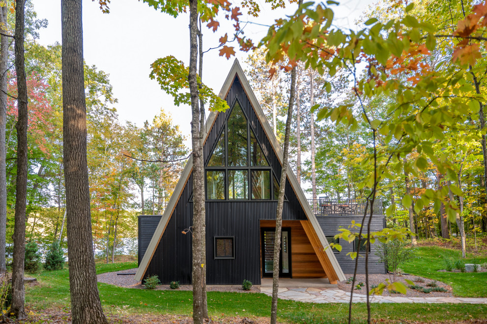 This is an example of a small and black modern tiny house in Minneapolis with mixed cladding, a pitched roof, a metal roof and a grey roof.