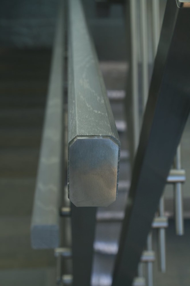 Modern metal stair covered by patina oak