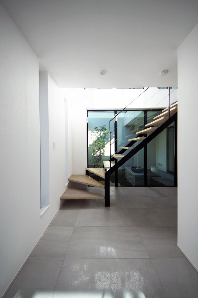 Inspiration for a large modern vestibule in Tokyo with white walls and slate floors.