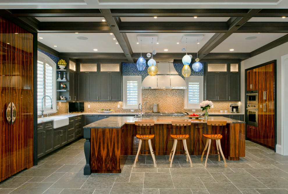 This is an example of an u-shaped kitchen in Baltimore with a farmhouse sink, flat-panel cabinets, brown cabinets, multi-coloured splashback, stainless steel appliances, with island, grey floor and coffered.