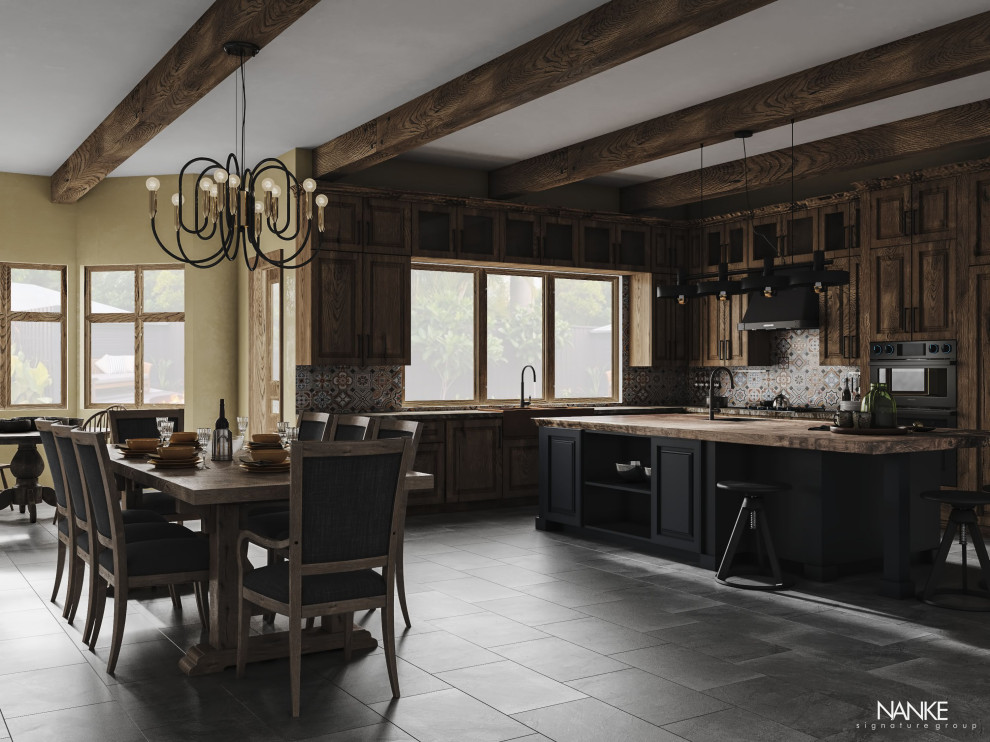 Large country l-shaped open plan kitchen in Phoenix with a farmhouse sink, raised-panel cabinets, dark wood cabinets, wood benchtops, multi-coloured splashback, ceramic splashback, black appliances, porcelain floors, with island, black floor and brown benchtop.
