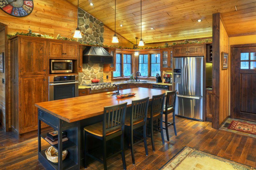 Inspiration for a rustic l-shaped dark wood floor kitchen remodel with shaker cabinets, dark wood cabinets, wood countertops, stainless steel appliances and an island