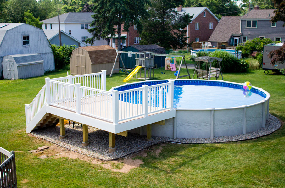 Design ideas for a mid-sized backyard round aboveground pool in New York.